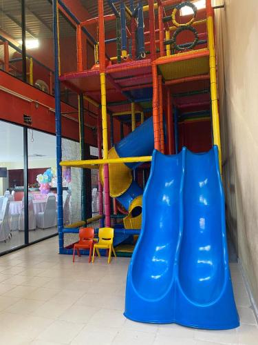 a playground with a blue slide in a room at Paris FC Express in Poza Rica de Hidalgo