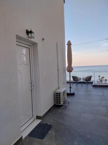 an open door to a balcony with a view of the ocean at Galazio Seaside Luxury Rooms & Coffee Shop in Platamonas