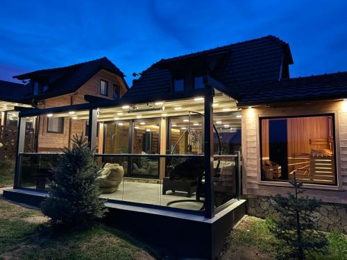 a house with glass doors and a porch at night at The Crown Lodge in Zlatibor