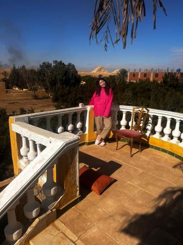 a woman standing on the ledge of a balcony at Sakkara pyramid inn hotel in Cairo