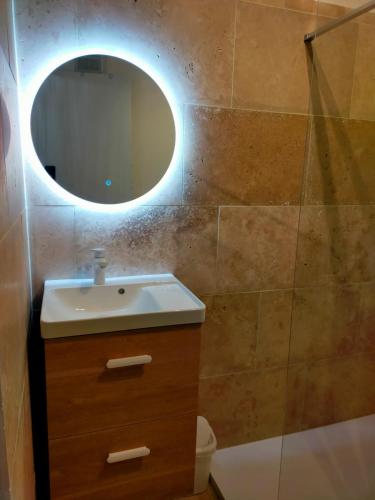 une salle de bain avec un lavabo et un miroir dans l'établissement Charmant petit studio, à La Grande Motte