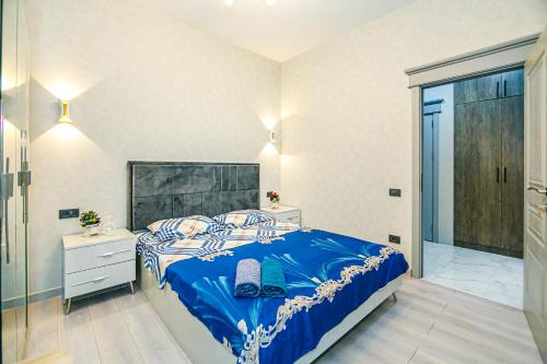 a bedroom with a bed with a blue comforter at Pole Star apartment by Bea Paradise in Baku