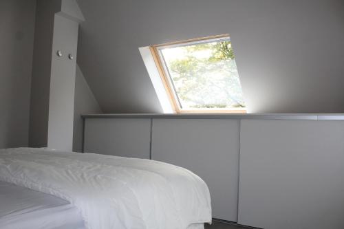 a bedroom with a bed with a window above it at L'Écureuil - Terrasses de Malmedy in Malmedy