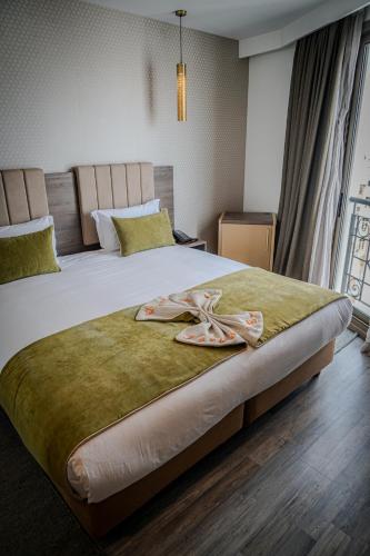 a bedroom with a large bed with two flip flops on it at AZ hôtel des arts in Rabat