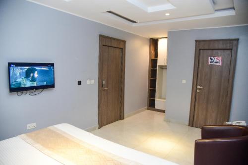 a living room with a tv on a wall at Hotel De Alommah Kubwa Abuja in Abuja