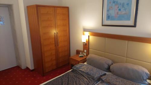 a hotel room with a bed and a wooden door at die Villa, Zimmer 22, DZ in Leverkusen