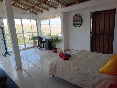 ein Schlafzimmer mit einem Bett und ein Zimmer mit einem Tisch in der Unterkunft Nebraska's Corner cerca de aeropuerto de Tababela in Yaruguí