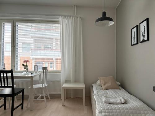 une chambre avec un lit, un bureau et une fenêtre dans l'établissement New Apartment HILLA near all the main city spots Public car parking, à Rovaniemi