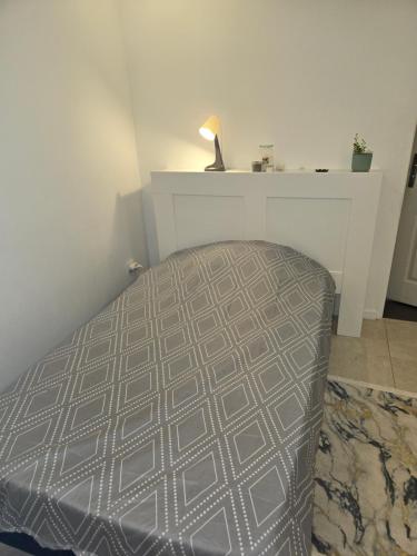 a bedroom with a bed and a table with a lamp at Studio de 14m2 dans une maison in Cagnes-sur-Mer