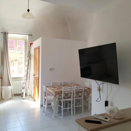 a dining room with a table and a flat screen tv at Casa FLAVIA in Serracapriola