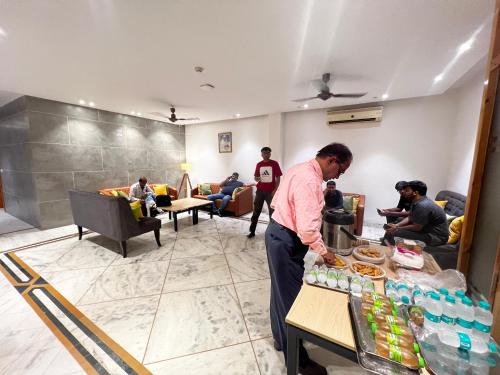 a man standing in front of a table with food at Divine Inn Hotel Near Rajouri Garden Main Market in New Delhi