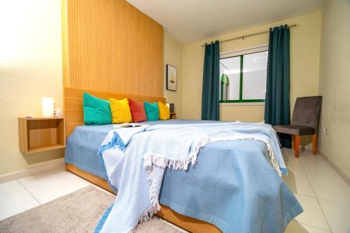 a bedroom with a large bed with colorful pillows at 1 bedroom for 4 people with pool Puerto de la Cruz in Puerto de la Cruz