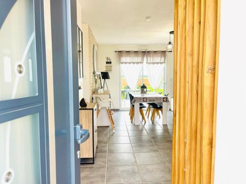 a room with a table and a kitchen with a door at Petite maison au calme in Poupry