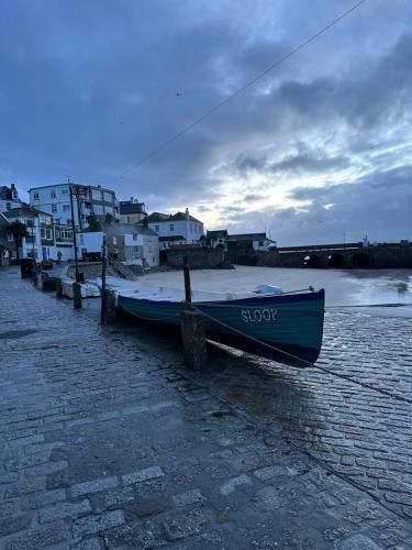 a blue boat sitting on the side of a beach at Sandals cottage in St Ives