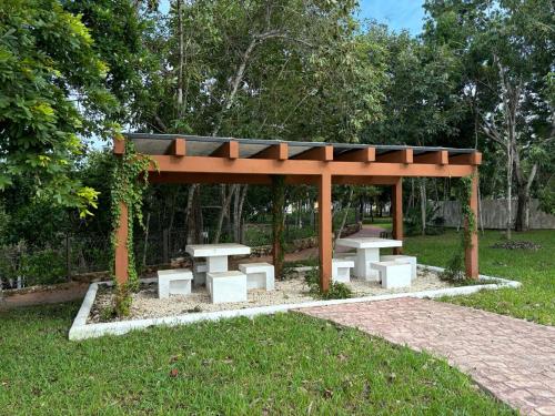 a pavilion with two picnic tables in a park at In Wotoch in Cancún
