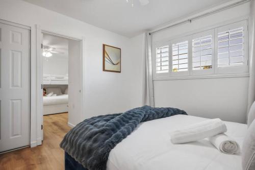 a bedroom with a white bed with a blanket on it at 4B House with Pool and BBQ Near Airport and Strip in Las Vegas