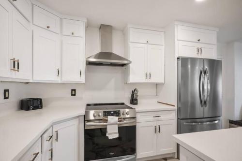 a kitchen with white cabinets and a stainless steel refrigerator at 4B House with Pool and BBQ Near Airport and Strip in Las Vegas