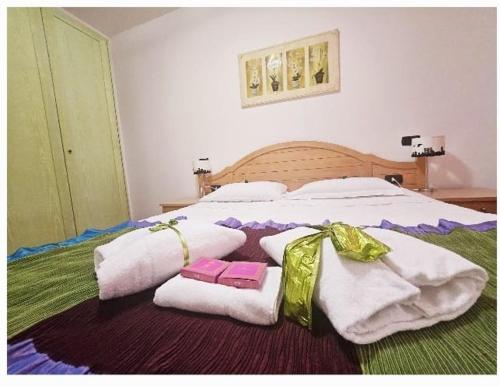 a large bed with white towels and bows on it at Sa Mirada Apartments in Villasimius