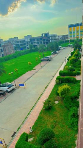 a street with a park with cars parked on it at Vrindavan suites omex in Vrindāvan