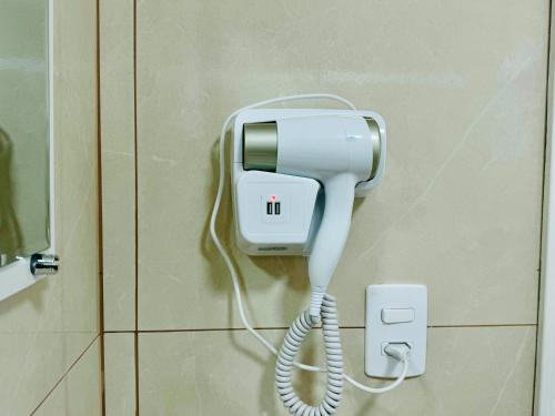 a phone hanging on a wall in a bathroom at Pôr do sol 300 metros do centro in Pato Branco