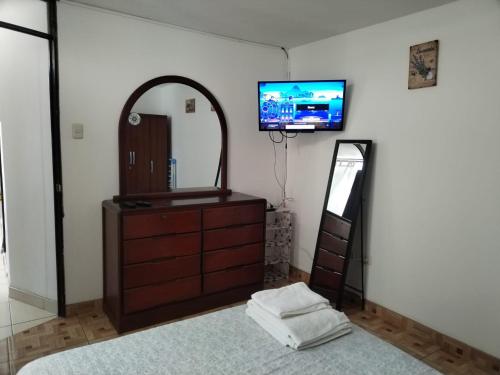 ein Schlafzimmer mit einer Kommode, einem Spiegel und einem TV in der Unterkunft Departamento Acogedor Céntrico en Huanchaco3B in Huanchaco