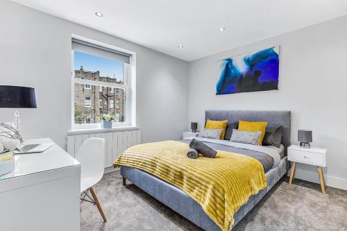 a bedroom with a bed and a desk and a window at LUX St Johns Wood Apartment - Sleeps 7 in London