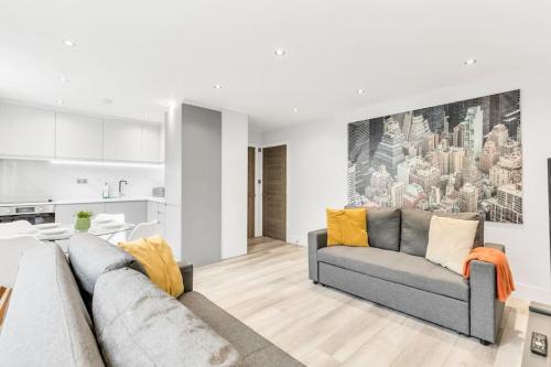 a living room with a couch and a kitchen at LUX St Johns Wood Apartment - Sleeps 7 in London