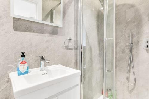 a bathroom with a sink and a shower at LUX St Johns Wood Apartment - Sleeps 7 in London