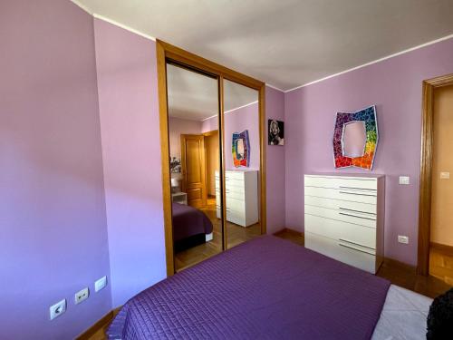 a purple bedroom with a bed and a mirror at Apartamento Marqués parking gratuito in Oviedo