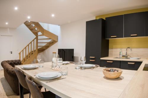 une salle à manger avec une grande table et une cuisine dans l'établissement Magnifique T4 hypercentre Rochefort, arrivée autonome, à Rochefort