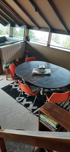 une salle à manger avec une table et des chaises dans une pièce dans l'établissement Châlet vue lac Léman à 1000 mètres d altitude, à Meillerie