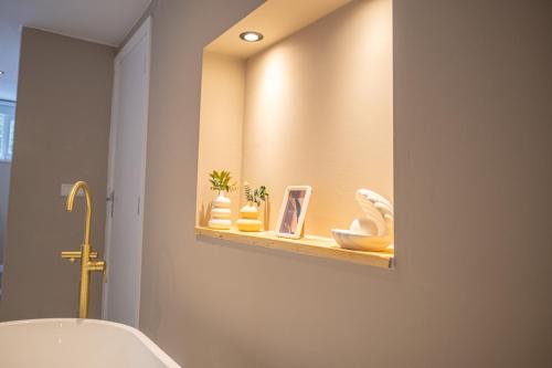 a bathroom with a tub and a shelf with vases at Wellnesshuisje Bunga Baco in Lanaken