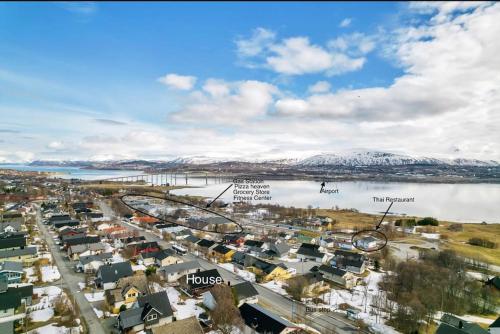 eine Luftblick auf eine Stadt mit schneebedeckten Bergen in der Unterkunft Cosy apartment close to Tromsø airport in Kvaloysletta