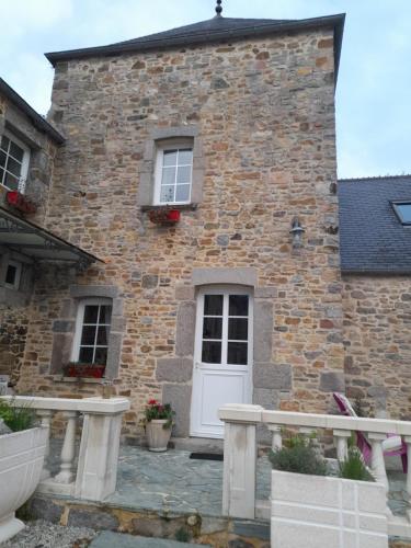 a brick house with a white door and windows at Domaine de la Tour carrée - 3 Chambres in Benoîtville