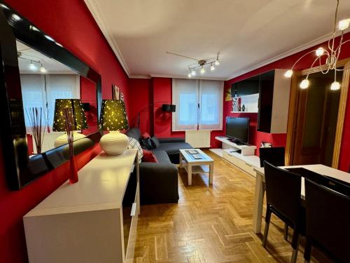 a living room with red walls and a couch at Apartamento Marqués parking gratuito in Oviedo