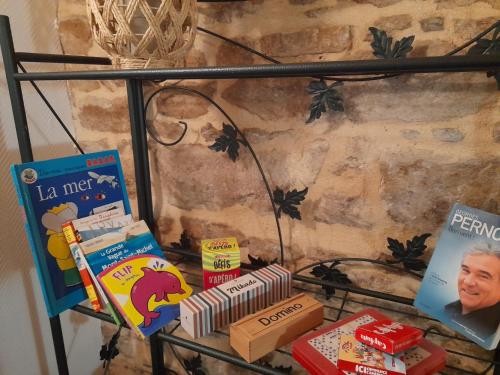 a shelf with books and other items on it at Domaine de la Tour carrée - 3 Chambres in Benoîtville