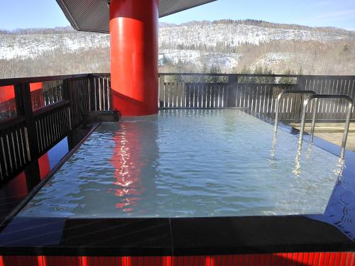 a swimming pool with a red pole and water at Hotel Kanronomori in Niseko