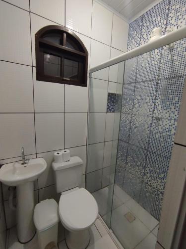 a bathroom with a toilet and a sink and a shower at Pouso Trindade in Trindade