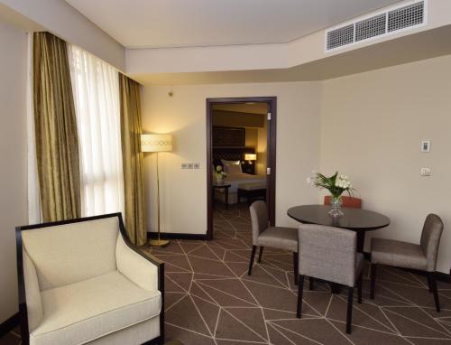 a hotel room with a table and chairs and a room at Pullman Zamzam Madina in Al Madinah