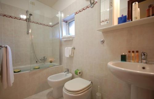 une salle de bain blanche avec toilettes et lavabo dans l'établissement Hotel Residence Vatican Suites, à Rome