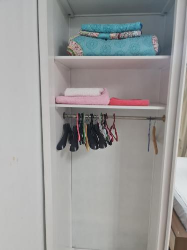 a closet with towels and shoes on a shelf at Madinty amazing view 2 rooms fully air-conditioned apartment at Madinty city for families only مدينتي in Madinaty