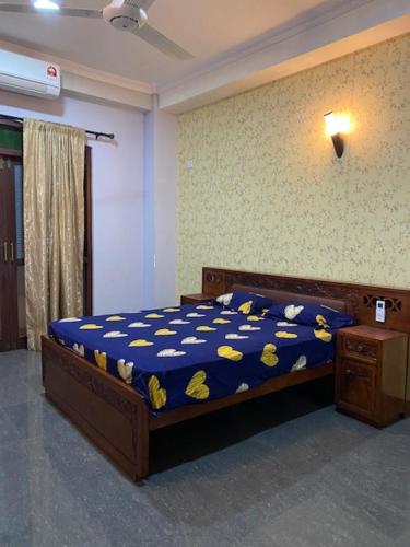 a bedroom with a bed with a blue comforter at Hayes Court Luxury Apartments in Meetotamulla