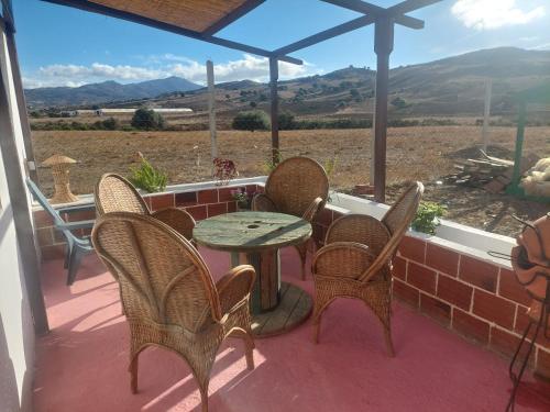 a table and chairs on a porch with a view at Chez le fermier Ferme pédagogique in Tetouan