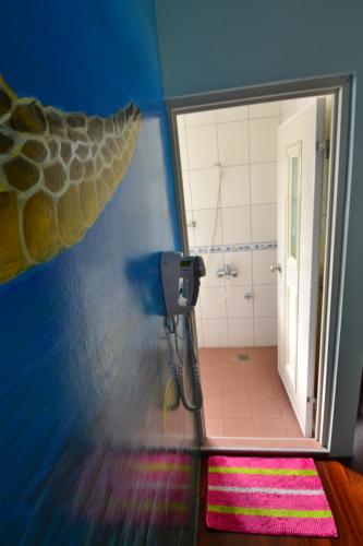 a small bathroom with a shower and a mirror at Haichian Hostel in Xiaoliuqiu