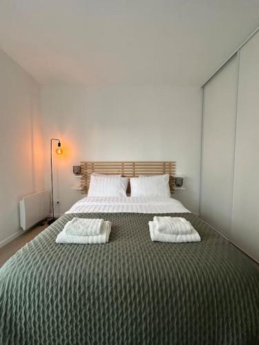 une chambre avec un grand lit avec deux oreillers dessus dans l'établissement Appartement moderne, Stade de France, Confort, Commodité, Tranquillité, à Aubervilliers