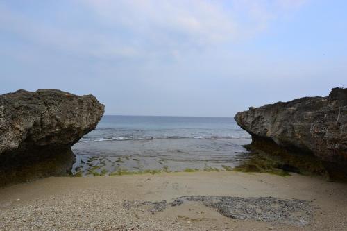 a beach with two large rocks and the ocean at Haichian Hostel in Xiaoliuqiu
