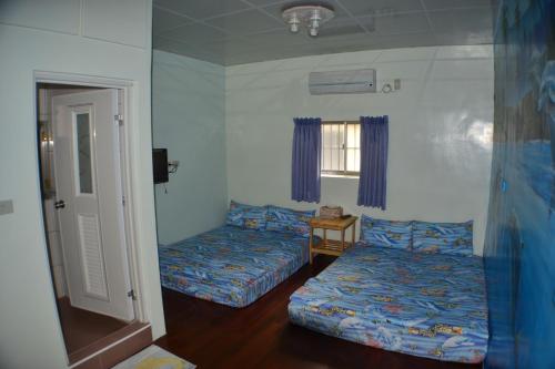 a bedroom with two beds and a window at Haichian Hostel in Xiaoliuqiu