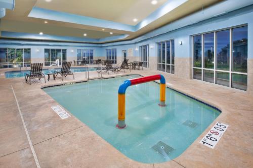 a swimming pool with a rail in the middle of it at Holiday Inn Express & Suites Milwaukee NW - Park Place by IHG in Milwaukee