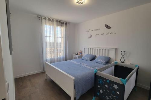une chambre avec un lit avec une couette bleue dans l'établissement COSY F2 Proche Disneyland Paris, à Serris