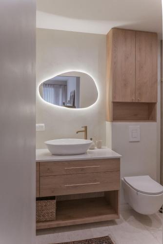 a bathroom with a sink and a toilet and a mirror at Apartament Vidok in Nowy Targ